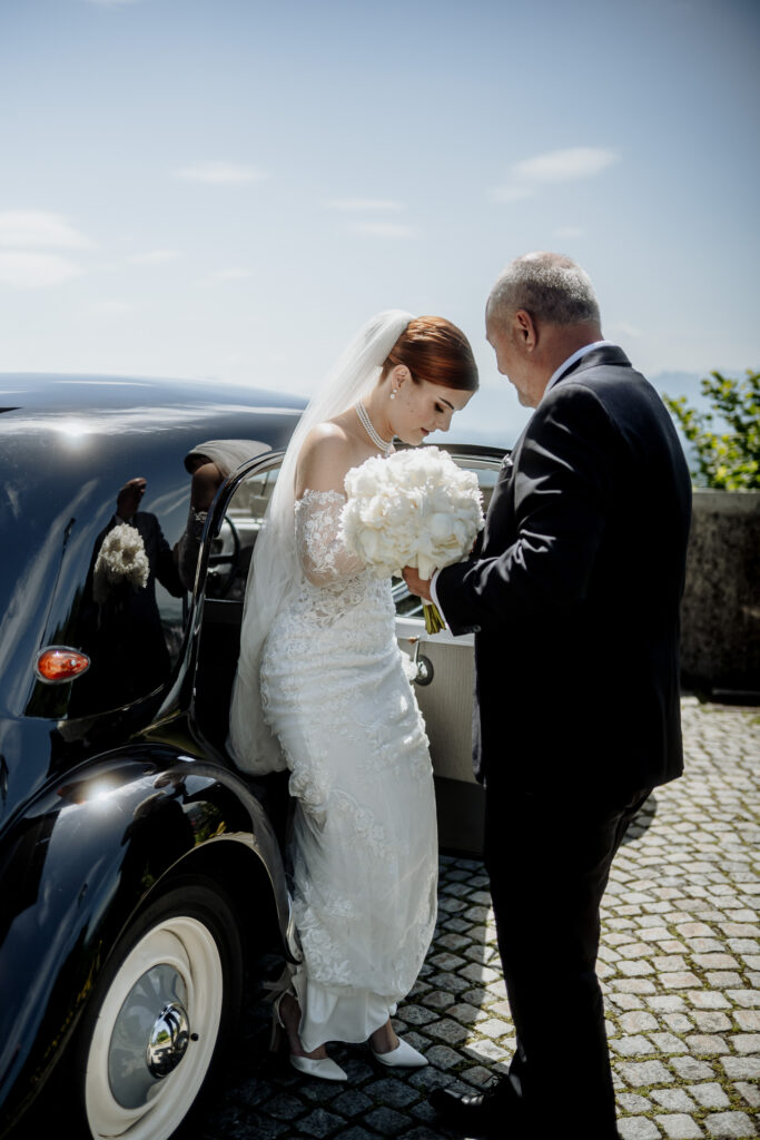 Braut beim Aussteigen aus dem Hochzeitsauto.